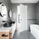 een grijze badkamer met een wit bad en een meubel van hout