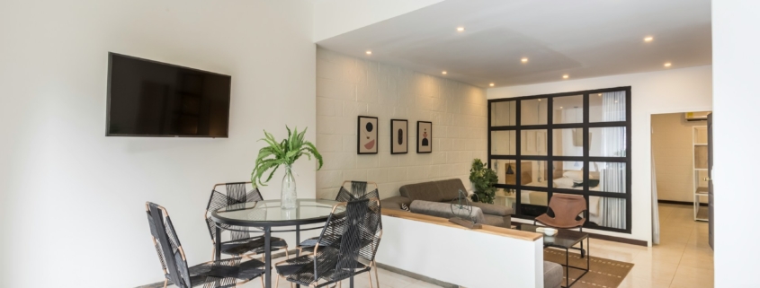 moderne woonkamer met een witte tegelvloer en eettafel met zwarte stoelen