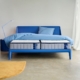 Moderne slaapkamer met een blauw bedframe en matras, gestyled met bijpassend blauw beddengoed en een minimalistisch interieur