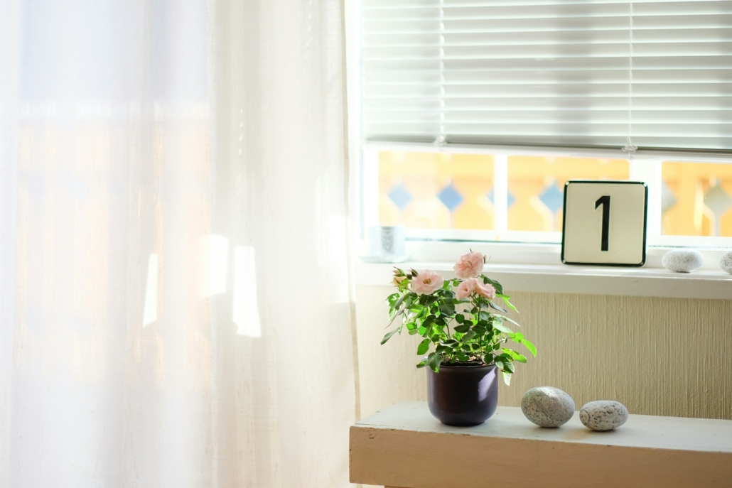 Zonwering met een plant en bord met het getal 1 op de vensterbank