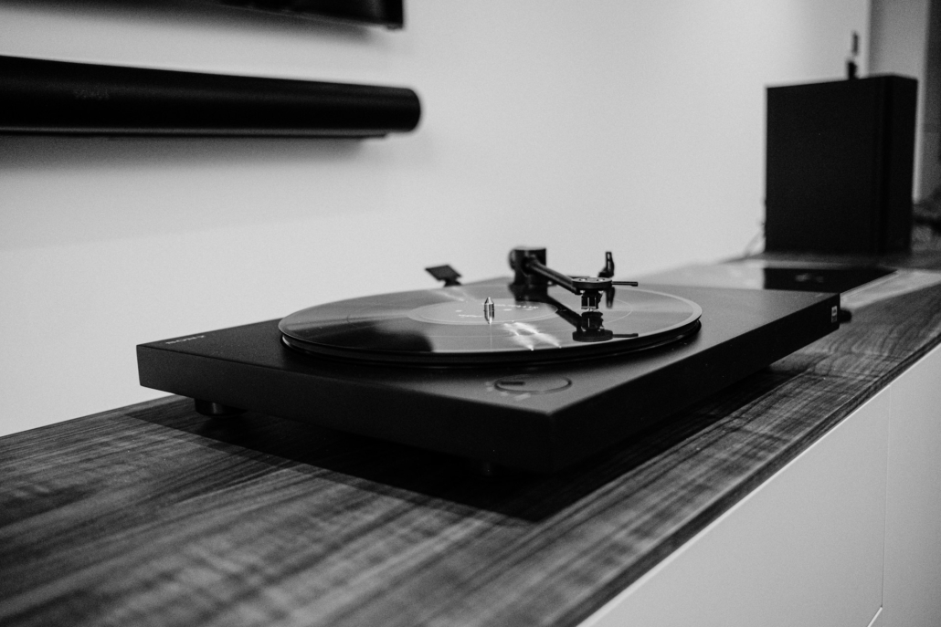 Stijlvolle platenspeler in een moderne woonkamer, ideaal voor muziekliefhebbers die genieten van analoge geluidservaring. Gecombineerd met een hoogwaardige geluidsversterker voor een rijke en nostalgische sfeer